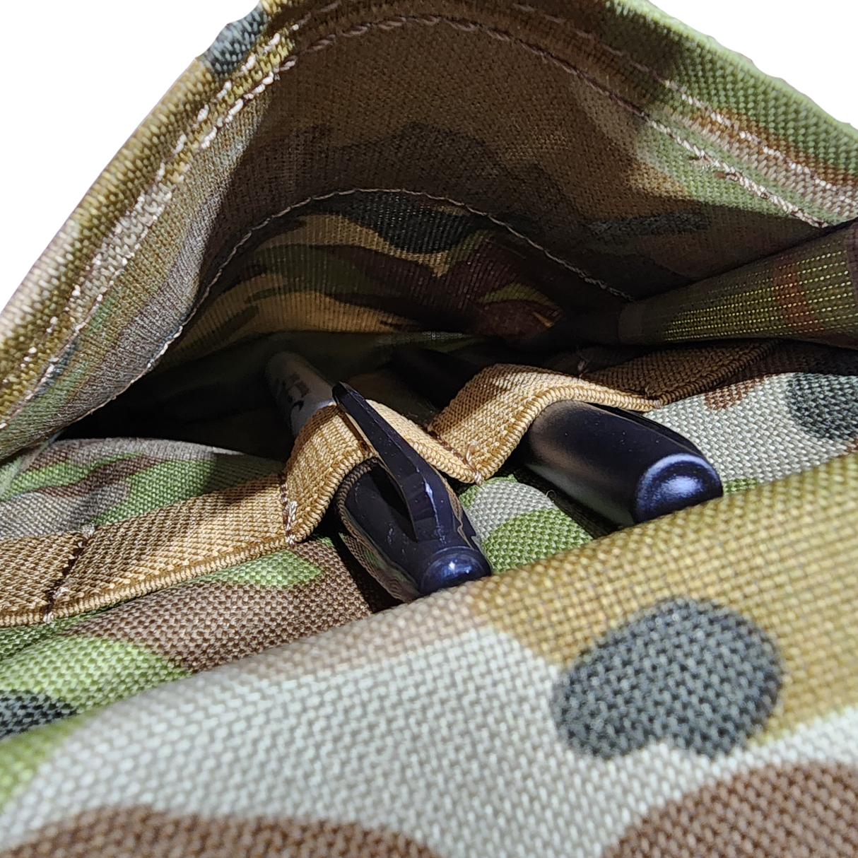 Close-up of a camouflage Notebook cover with pens, detailed fabric texture.